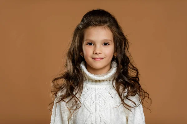 Маленька дівчинка в білому светрі дивиться на камеру — стокове фото