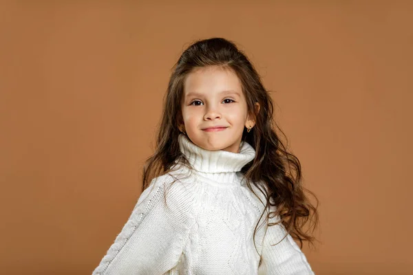 Kleines Mädchen im weißen Pullover blickt in die Kamera — Stockfoto