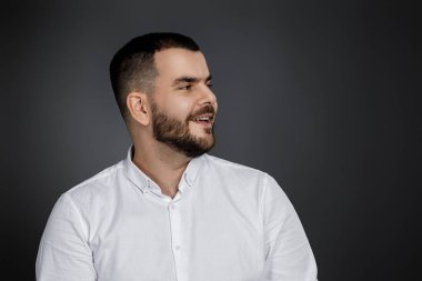 Gülümseyen yakışıklı sakallı adamın yakın plan portresi.