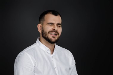 Mutlu yakışıklı sakallı adam gülüyor.