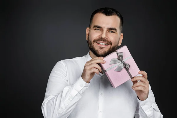 Hombre barbudo en camisa blanca sosteniendo caja de regalo —  Fotos de Stock
