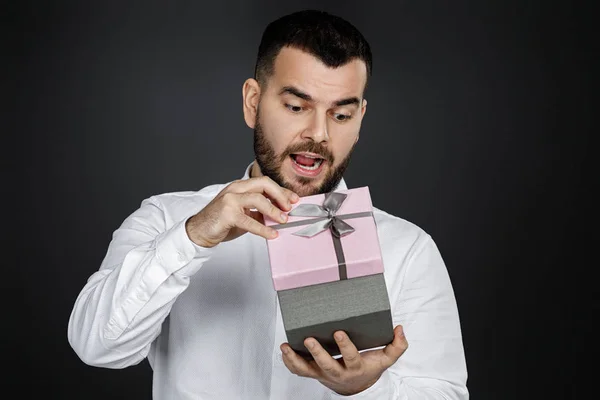 Бородатый мужчина в белой рубашке с подарочной коробкой — стоковое фото