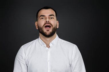 Şaşırmış, sakallı, yüzünde şok ifadesi olan yakışıklı adam.