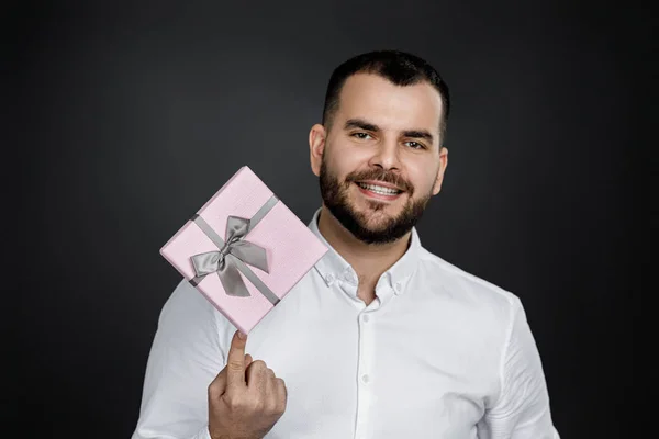 Hombre barbudo en camisa blanca sosteniendo caja de regalo — Foto de Stock