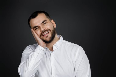 Gülümseyen yakışıklı sakallı adamın yakın plan portresi.