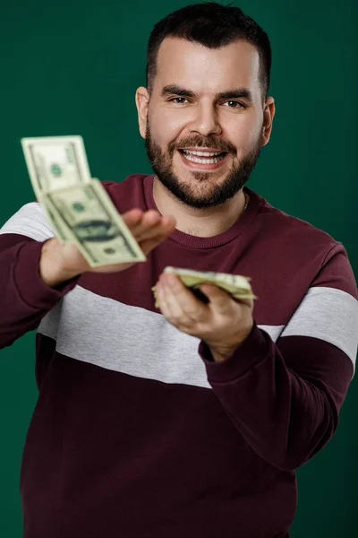 young man throwing money banknotes at camera