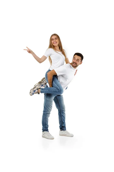 Chłopak dając piggyback do dziewczyny na białym tle — Zdjęcie stockowe