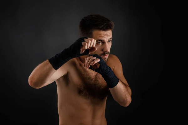 Boxer man ukazuje různé pohyby na černém pozadí — Stock fotografie