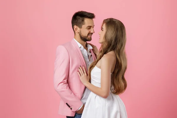 Feliz pareja enamorada abrazando sobre fondo rosa. Día de San Valentín — Foto de Stock