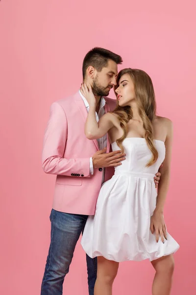Šťastný zamilovaný pár objímající se na růžovém pozadí. den svatého Valentýna — Stock fotografie