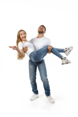 Bir adam kız arkadaşını kollarında tutuyor.