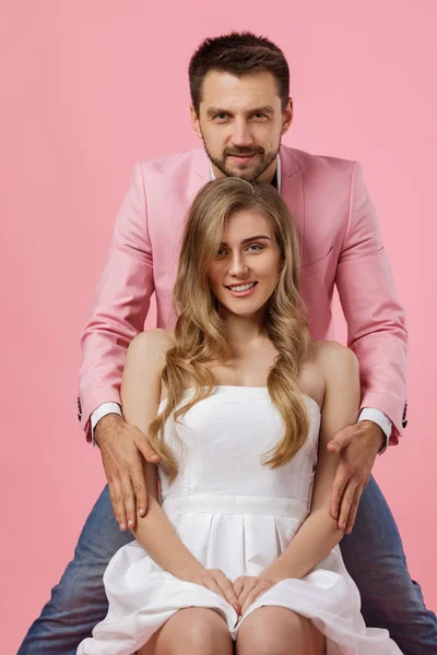 Lyckligt par kär i rosa bakgrund. — Stockfoto