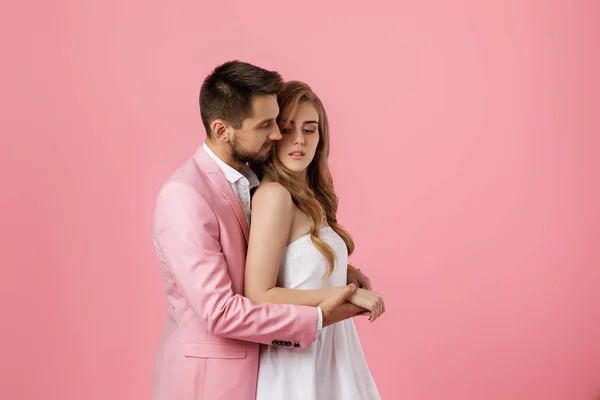 Feliz pareja enamorada abrazando sobre fondo rosa. Día de San Valentín — Foto de Stock