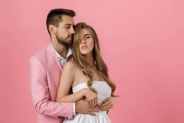 Feliz pareja enamorada abrazando sobre fondo rosa. Día de San Valentín — Foto de Stock