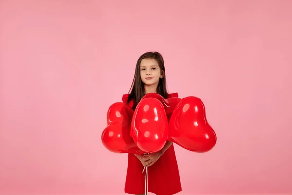 Enfant fille tenant ballon rouge en forme de coeur — Photo