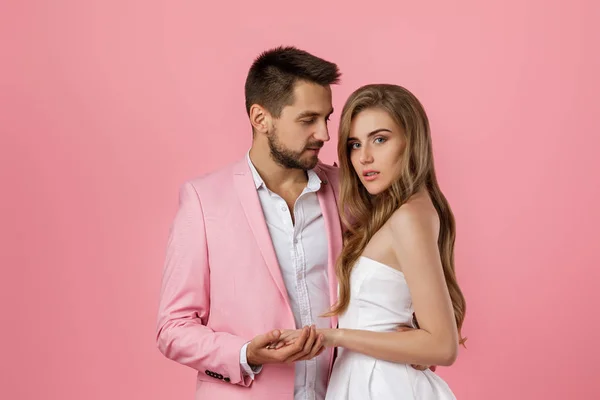 Feliz pareja enamorada abrazando sobre fondo rosa. Día de San Valentín — Foto de Stock