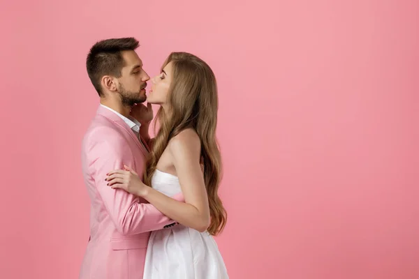 Feliz pareja enamorada abrazando sobre fondo rosa. Día de San Valentín — Foto de Stock