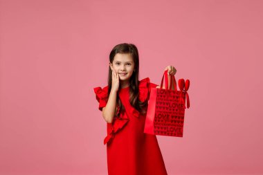 child girl holding red paper shopping bag