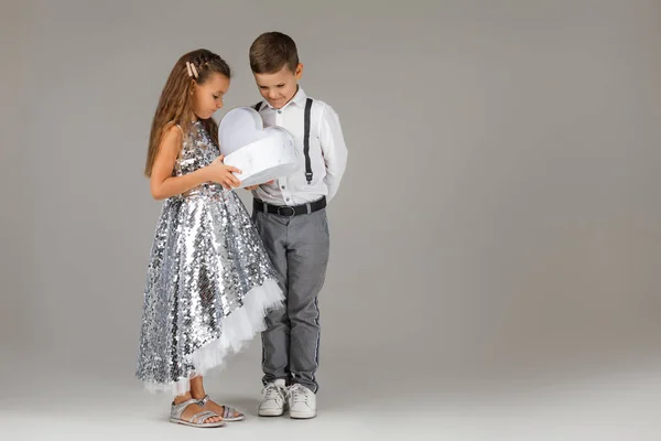 Liten pojke ger presentförpackning till fashionabla barn flicka — Stockfoto