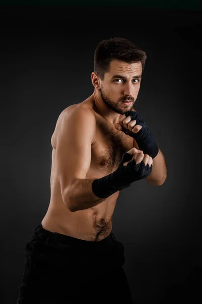 Boxeador hombre muestra los diferentes movimientos sobre fondo negro — Foto de Stock