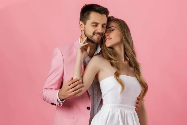 Šťastný zamilovaný pár objímající se na růžovém pozadí. den svatého Valentýna — Stock fotografie