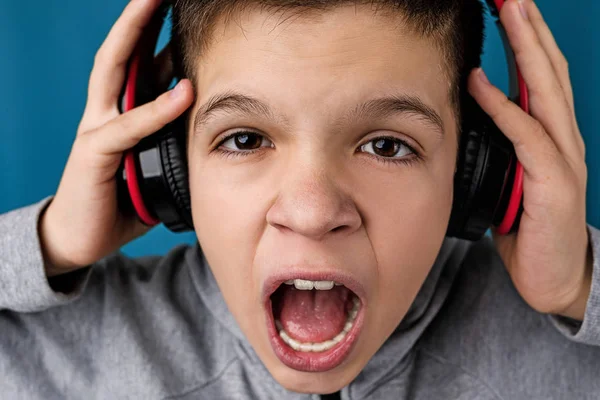 Child boy enjoys listens to music in headphones — Stock Photo, Image