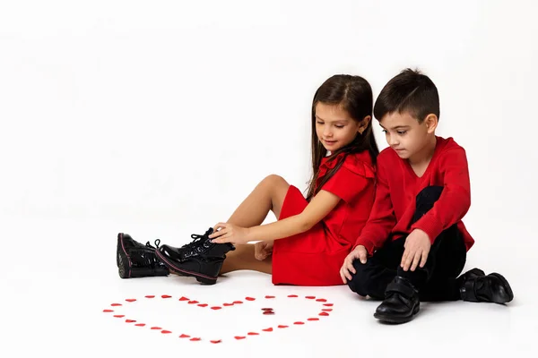 couple girl and boy make big heart shape out of small paper hearts