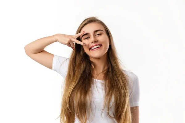 Smiling young woman showing victory sign — Stock Photo, Image