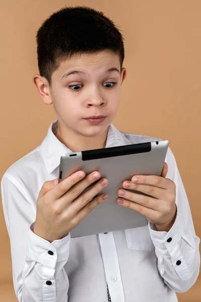 Pequeño chico sorprendido usando tableta — Foto de Stock