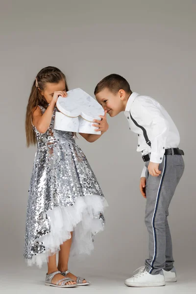 Liten pojke ger presentförpackning till fashionabla barn flicka — Stockfoto