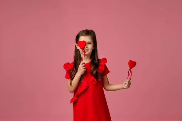 Niña sonriente con dos corazones rojos — Foto de Stock