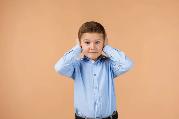 Little child boy covering his ear with his hand. — Stock Photo, Image