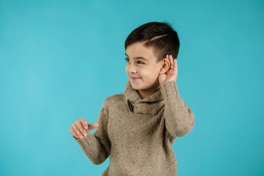 happy little child boy making hearing gesture