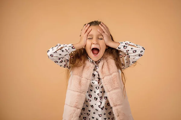 Little girl screaming on beige background. — Stockfoto