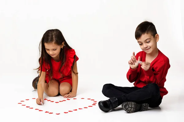 Par flicka och pojke göra stora hjärta form av små pappershjärtan — Stockfoto