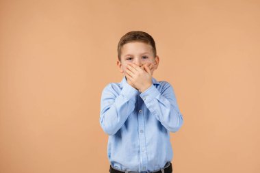 Çocuk eliyle ağzını kapatıyor.