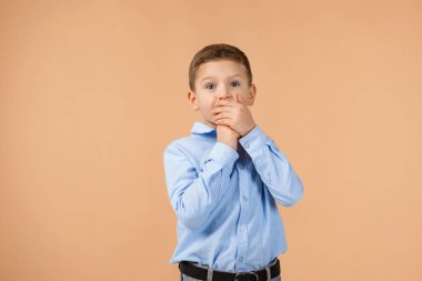 Çocuk eliyle ağzını kapatıyor.