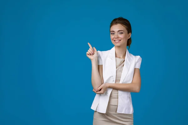 Mujer de negocios con chaqueta blanca apuntando hacia arriba —  Fotos de Stock