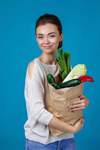 Mujer sosteniendo una bolsa llena de víveres — Foto de Stock