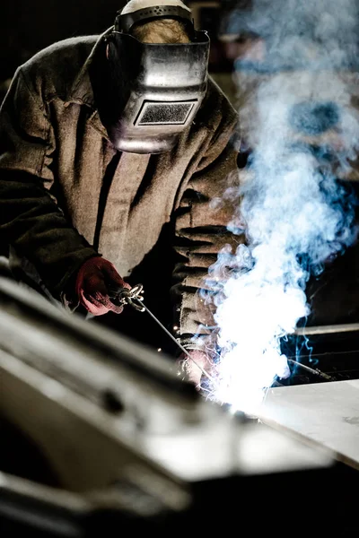 Trabajador en uniforme protector y máscara de soldadura de metal . — Foto de Stock