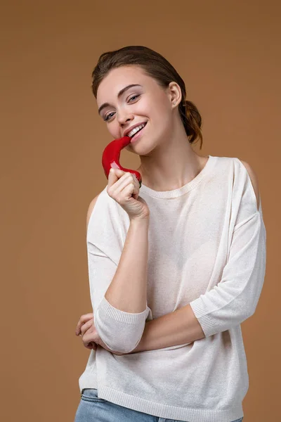 Портрет красивой молодой женщины, кусающей перец чили — стоковое фото