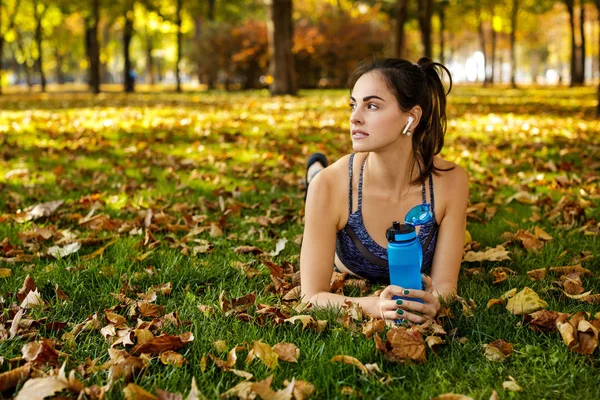 Woman with a bottle of water resting after training — Stock Photo, Image