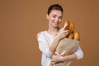 Genç bir kadın ekmek tutuyor.