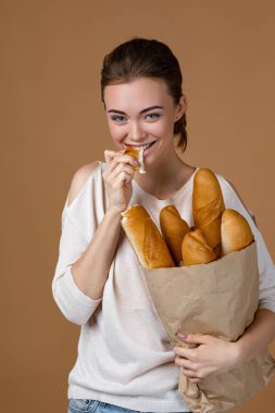 Genç bir kadın ekmek tutuyor.