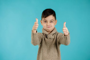 Sevimli küçük çocuk başparmak hareketi yapıyor.