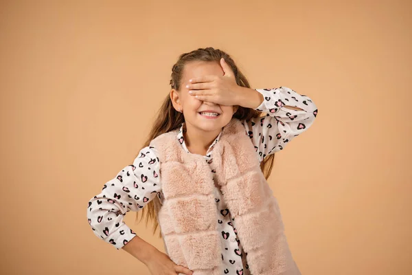 Sorridente bambina chiude gli occhi con la mano — Foto Stock