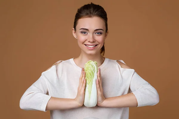 Молода жінка тримає капусту — стокове фото