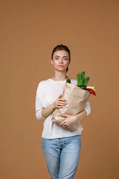 woman holding a shopping bag full of groceries
