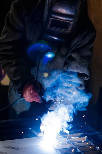 Worker in protective uniform and mask welding metal. — Stock Photo, Image
