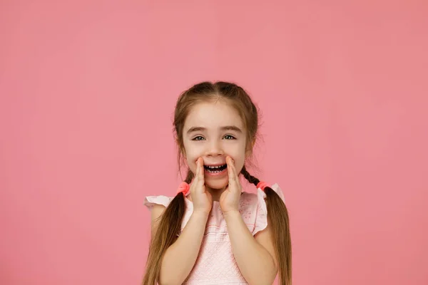 Słodkie mała dziewczynka krzycząc i trzymając jej rękę w pobliżu jej usta. — Zdjęcie stockowe
